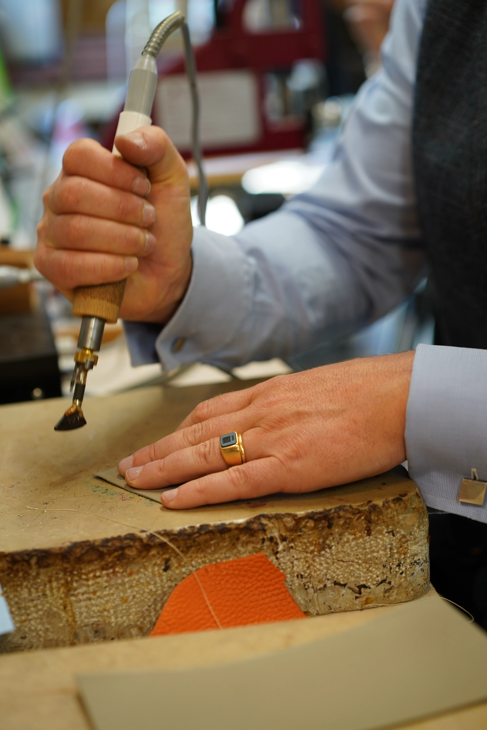 Henry de Freycinet working leather by hand at a workbench