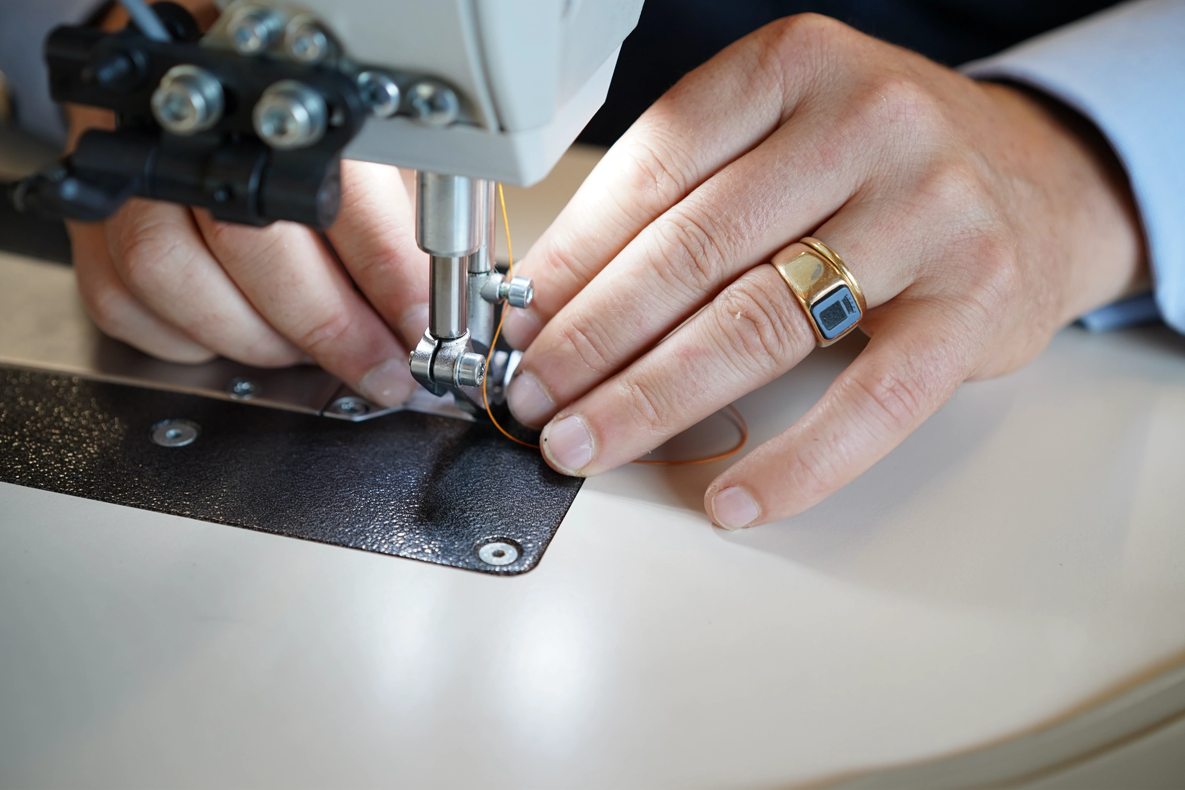Henry de Freycinet stitching leather at a sewing machine