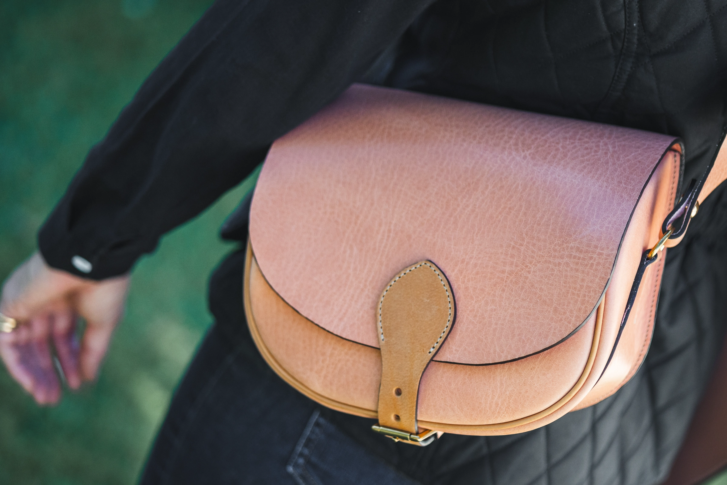 A person wearing a Henry de Freycinet leather shoulder bag